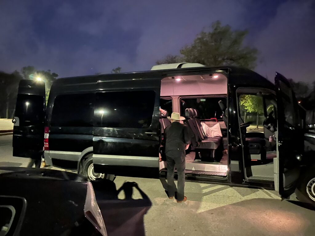 Country cover band loading their gear into a black rental van