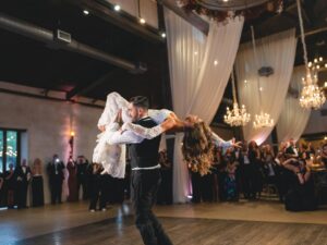 A groom lifting a bride to the best country wedding songs played by all hat no cadillac
